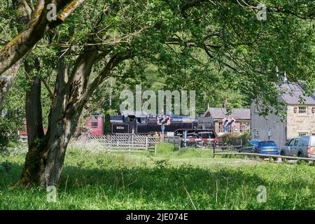 SteamTrain che trattiene il traffico sulla ferrovia North Yorks Moors all'incrocio ferroviario di Levisham, North Yorkshire Moors National Park, Northern England, UK Foto Stock