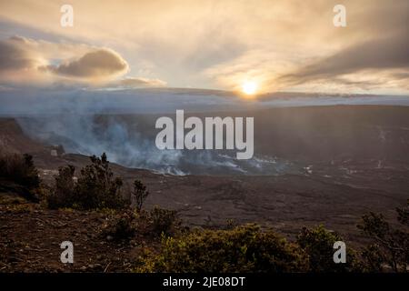 Tramonto dietro il vulcano Mauna Loa, eruzione attiva del vulcano Kilauea di fronte, Hawai'i Volcanoes National Park, Big Island, Hawaii, USA Foto Stock