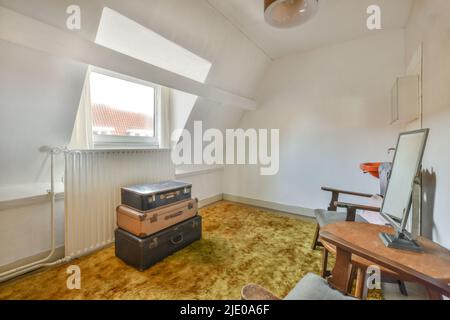 Ampia e luminosa mansarda per il lavoro e il relax, con una splendida vista dalla finestra Foto Stock