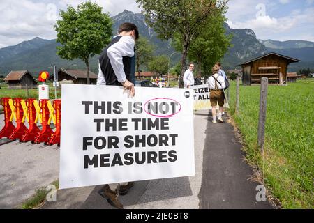 Elmau, Germania. 24th giugno 2022. I manifestanti in costume tradizionale lasciano l'area di dimostrazione vicino al centro stampa con i cartelli come prescritto dalla polizia. Il vertice del G7 è previsto per il 26-28 giugno 2022 presso il Castello di Elmau. Credit: Peter Kneffel/dpa/Alamy Live News Foto Stock