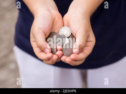 Primo piano moneta nella mano dei bambini. Concetto di business e finanza Foto Stock