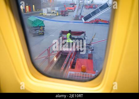 Amburgo, Germania. 23rd giugno 2022. Un dipendente dell'aeroporto scarica le valigie da un aereo su un carrello . Credit: Jonas Walzberg/dpa/Alamy Live News Foto Stock