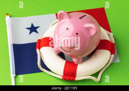 Piggy banca, salvagente e bandiera su sfondo blu, il concetto di salvare l'economia di Panama Foto Stock