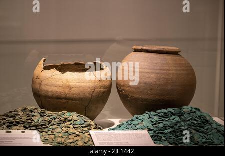 Trier, Germania. 24th giugno 2022. Le monete di bronzo si trovano di fronte alle navi romane nella mostra "la caduta dell'Impero Romano" al Treviri Rheinisches Landesmuseum. La mostra è visibile dal 25.06.2022 al 27 novembre nel Rheinisches Landesmuseum, nello Stadtmuseum e nel Museum am Dom. Credit: Harald Tittel/dpa/Alamy Live News Foto Stock