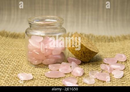 Diversi pezzi di quarzo rosa lucido su sfondo rosa glitter. Vista dall'alto della fotografia a colori dal minimo Foto Stock