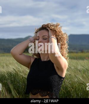 Giovane ragazza rosa che accarezza i capelli con le mani. Foto Stock