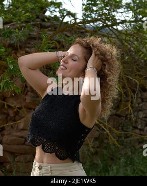 Giovane ragazza rosa che accarezza i capelli con le mani. Foto Stock