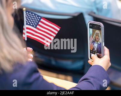 Austin Texas USA, 24 giugno 2022: Un nuovo cittadino che presto sarà prende un selfie in attesa che inizi la cerimonia per 95 nuovi cittadini provenienti da 40 paesi stranieri presso la Biblioteca centrale di Austin. La cerimonia è uno dei numerosi eventi di cittadinanza previsti questa estate nel Texas centrale. Credit: Bob Daemmrich/Alamy Live News Foto Stock