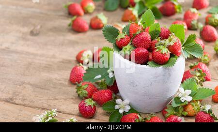 Fragole biologiche belle. Ciotola bianca rustica piena di fragole fresche sul tavolo. Foto Stock