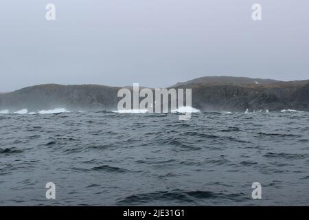 L'onda si schiantando contro un piccolo iceberg che galleggia in mare Foto Stock