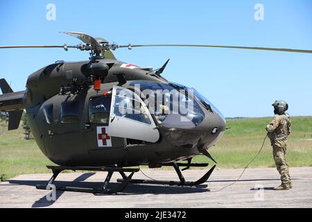 Soldati assegnati a Delta Company, 1st Battaglione, 112th Aviation Regiment, North Dakota Army National Guard, preparano l'elicottero per il volo durante l'esercitazione di addestramento del coyote d'oro a Camp Rapid, South Dakota, 16 giugno 2022. Golden Coyote è un esercizio di formazione in tre fasi, basato su scenari, condotto nelle Black Hills del South Dakota e del Wyoming, che consente ai comandanti di concentrarsi sui requisiti delle attività essenziali della missione, sulle attività dei guerrieri e sulle esercitazioni di battaglia. (STATI UNITI Foto dell'esercito di Pvt. Joanna Whittaker) Foto Stock