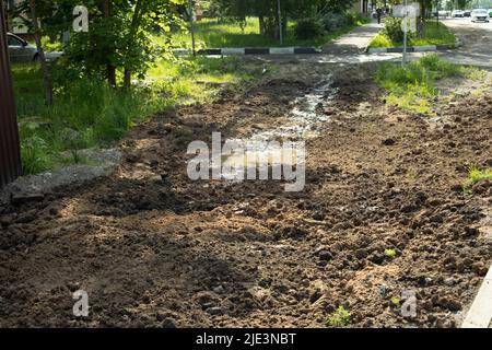 Terreno scavato su strada. Tubi fognari interrati. Molta sporcizia su strada. Terreno scavato in città. Foto Stock