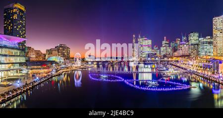 Breve e luminoso panorama al tramonto del porto di Darling Cockle Bay nel CBD di Sydney allo spettacolo del festival della luce di Vivid Sydney. Foto Stock