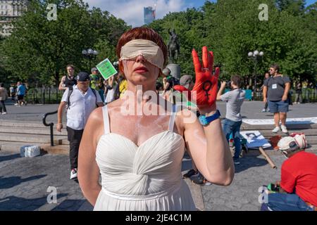 New York, Stati Uniti. 24th giugno 2022. CITTÀ DI NEW YORK - 24 GIUGNO: Una donna tiene la mano dipinta di rosso simboleggiando il sangue mentre la gente si riunisce a Union Square per protestare contro la decisione della Corte Suprema nel caso Dobbs contro Jackson Women's Health il 24 giugno 2022 nel distretto di Manhattan di New York City. La decisione della Corte nel caso Dobbs contro Jackson Women's Health capovolge la storica causa Roe contro Wade di 50 anni, eliminando un diritto federale all'aborto. Credit: Ron Adar/Alamy Live News Foto Stock