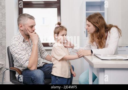 una pediatra femmina esamina una bambina durante un appuntamento in un ufficio medico. medico di famiglia. medicina di assicurazione. Foto Stock