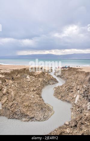 Buca piena di acque turchesi, vicino alla costa del Mar Morto. Foro formato quando il sale sotterraneo è dissolto da intrusione di acqua dolce, dovuto la caduta continua del livello del mare. . Foto di alta qualità Foto Stock