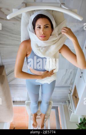 giovane donna araba che fa sport a casa con hijab Foto Stock