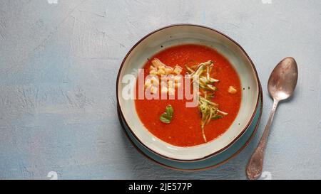 Ciotola con zuppa di pomodoro Gazpacho fatta in casa, crostini e cetrioli tagliati a fette. Zuppa spagnola a base di pomodoro freddo Foto Stock