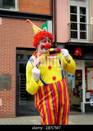 L'uomo si vestì come un clown in posa per una foto nella città vecchia di Düsseldorf/Germania. La Città Vecchia è una popolare area turistica. Foto Stock