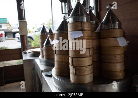 Pila torre di Dim Sum Bamboo Steamers su stufa in cucina di ristorante. Foto Stock