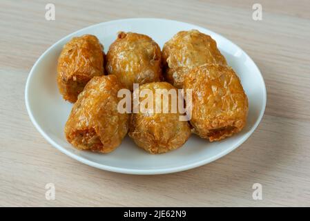 Un delizioso involtini di carne di granchio fritto caldo su piatto bianco. Foto Stock