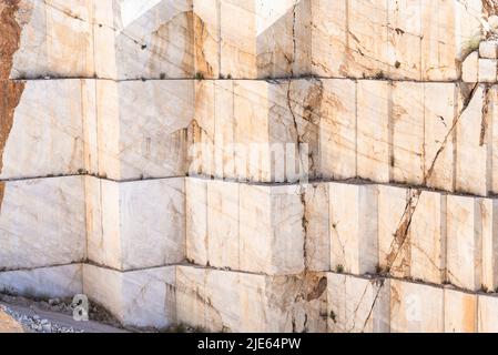 Parete rocciosa con i bordi tagliati dei blocchi di pietra in una cava di marmo nei pressi di Orosei sulla costa orientale della Sardegna, Baronia, Italia Foto Stock