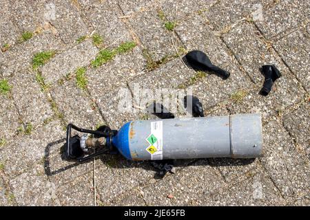 Bombole con protossido di azoto e palloncini neri lasciate nel parcheggio dopo l'uso come droga all'Aia Foto Stock