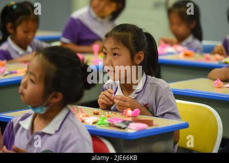 (220625) -- BAOTOU, 25 giugno 2022 (Xinhua) -- gli studenti imparano a fare artigianato durante un'attività post-lezione in una scuola elementare a Baotou, nella regione autonoma della Mongolia interna della Cina settentrionale, 24 giugno 2022. Le scuole di Baotou hanno organizzato varie attività dopo le lezioni per arricchire il tempo scolastico degli studenti. (Xinhua/Peng Yuan) Foto Stock