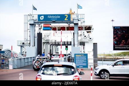 Norddeich, Germania. 25th giugno 2022. I turisti guidano le loro auto attraverso un ponte di traghetti nel porto su un traghetto operato da AG Reederei Norden-Frisia per viaggiare verso l'isola di Norderney. La Renania settentrionale-Vestfalia è il primo stato tedesco ad iniziare la sua vacanza estiva. Credit: Hauke-Christian Dittrich/dpa/Alamy Live News Foto Stock