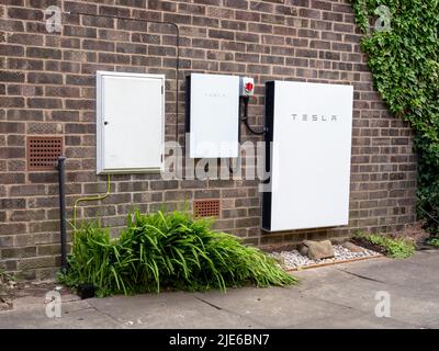 Sistema di stoccaggio delle batterie Tesla Powerwall 2 e Backup Gateway 2 installato su una parete di un edificio in mattoni Foto Stock