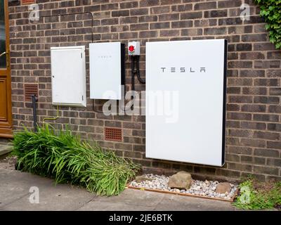 Sistema di stoccaggio delle batterie Tesla Powerwall 2 e Backup Gateway 2 installato su una parete di un edificio in mattoni Foto Stock