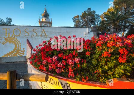 ROWBOAT PIENO DI FIORI ROSSI GERANI FARO DI TOSSA (©UNATTRIBUITI 1917) CAP DE TOSSA TOSSA DE MAR COSTA BRAVA GERONA CATALONIA SPAGNA Foto Stock