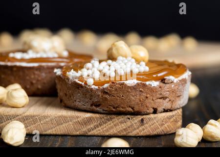 tartine di cioccolato con ripieno crema e caramello salato con noci, tartine con nocciole e crema con caramello Foto Stock