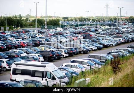 Norddeich, Germania. 25th giugno 2022. Numerosi veicoli di turisti in vacanza sulle isole di Norderney e Juist sono parcheggiati in un parcheggio dietro la diga vicino al terminal dei traghetti nel porto. La Renania settentrionale-Vestfalia è il primo stato tedesco ad iniziare la sua vacanza estiva. Credit: Hauke-Christian Dittrich/dpa/Alamy Live News Foto Stock