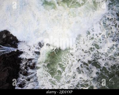 Vista dall'alto di una tempesta nell'oceano, ondate bianche e schiumose che si infrangono sulla riva. Elemento, rabbia, pericolo. La bellezza e la maestosità della natura. Ritorno della natura Foto Stock