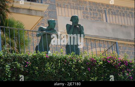 Due statue in piedi sul balcone appoggiate ai corrimano. Foto Stock