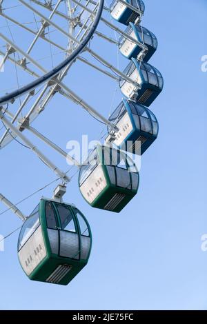 Primo piano di cabine colorate di ruota gigante ferris nel parco di divertimento contro il cielo blu Foto Stock
