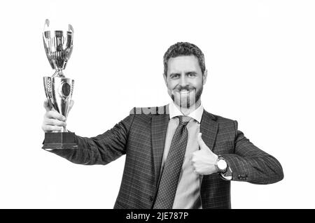 Happy boss tenere coppa d'oro dando pollici su mano gesto isolato su bianco, meglio Foto Stock