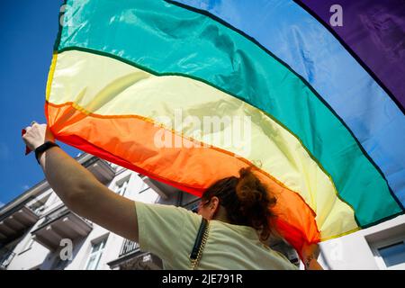 Varsavia, Polonia. 25th giugno 2022. Una donna tiene sopra la testa la bandiera arcobaleno mentre partecipa alla sfilata di uguaglianza di Varsavia. La sfilata è stata organizzata per promuovere l'uguaglianza sociale e richiamare l'attenzione sui problemi che la comunità LGBT deve affrontare in Polonia. Quest'anno la Warsaw Equality Parade ha ospitato il Kyiv Pride, la più grande sfilata di diritti LGBTQ in Ucraina. Oltre agli slogan LGBTQ e Equality, i partecipanti hanno mostrato il loro sostegno contro la guerra e le invasioni russe dell'Ucraina. Credit: SOPA Images Limited/Alamy Live News Foto Stock