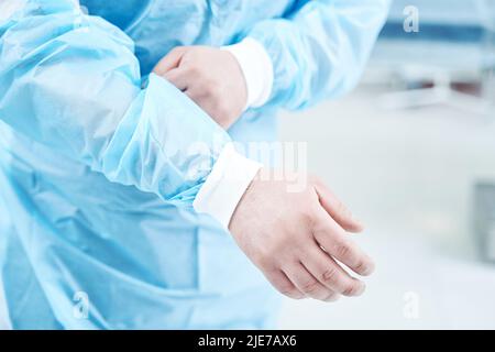 Primo piano di un medico non riconosciuto che mette su uniforme Foto Stock