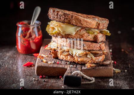 Toast fatti in casa e gustosi con formaggio, funghi e cipolla. Toast con salsa rossa, funghi e formaggio. Foto Stock