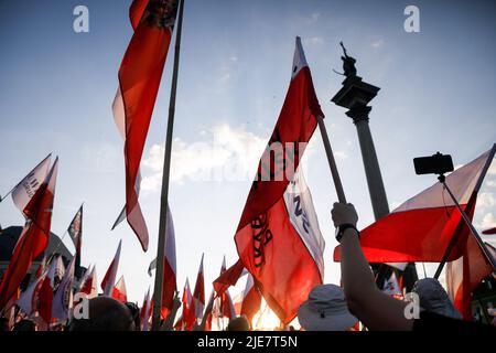 Varsavia, Polonia. 25th giugno 2022. I manifestanti ondano bandiere polacche durante la seconda marcia di Dmowski al Castello. La seconda marcia di Dmowski al Castello è stata organizzata dai nazionalisti polacchi. Roman Dmowski era un politico polacco, co-fondatore e capo ideologo della democrazia nazionale polacca. Durante la marcia i partecipanti con la bandiera nazionale polacca camminano per le strade di Varsavia con il busto di Dmowski. Credit: SOPA Images Limited/Alamy Live News Foto Stock