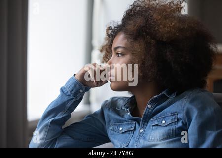 Primo piano faccia africano triste pensieroso adolescente ragazza che guarda a distanza Foto Stock