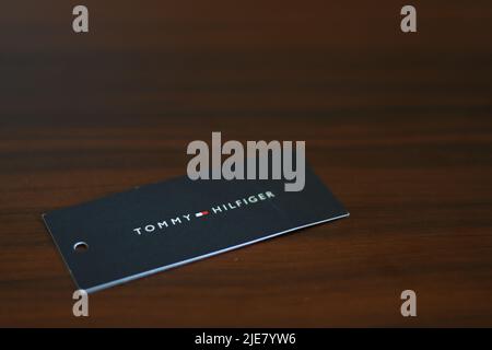 Tommy Hilfiger tag su un tavolo di legno Foto Stock