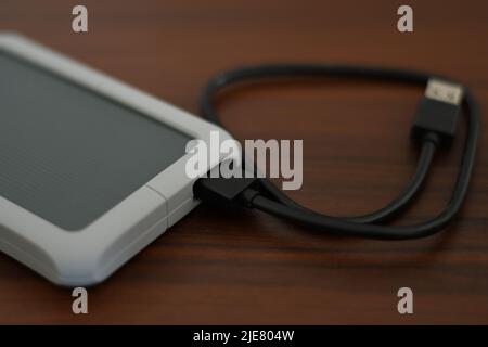 HDD portatile con il cavo su un tavolo Foto Stock