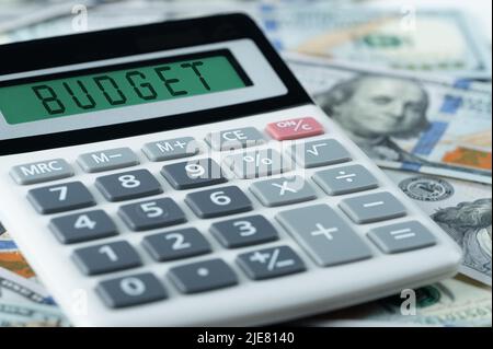 Concetto di budget testo di budget su calcolatrice. Testo di budget su calcolatrice su sfondo di dollari. Concetto di finanza e contabilità. Banconote e calcoli USA Foto Stock