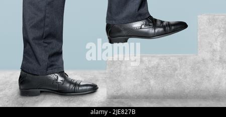 Vista laterale dell'uomo che sale su scale di cemento. Concetto di successo e il raggiungimento del vostro obiettivo. Passi avanti verso un successo. Sezione bassa del walkin dell'uomo d'affari Foto Stock