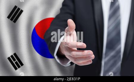 Business coreano, politica, cooperazione e concetto di viaggio. Mano su bandiera di sfondo coreano. Foto Stock