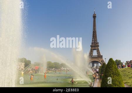 PARIGI, FRANCIA, 20 GIUGNO 2022: Turisti e locali che fanno un bagno nei Jardins du Trocadero Guardians del Trocadero sotto l'acqua potente Foto Stock