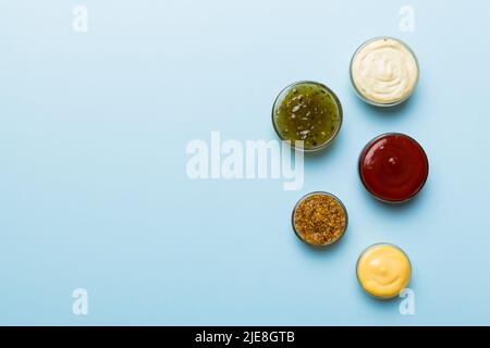 Diversi tipi di salse in ciotole su un pannello colorato . Vista dall'alto, vari salse copia spazio. Foto Stock